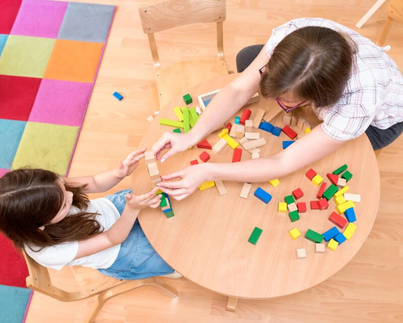 Little boy having fun and playing wooden toy drum