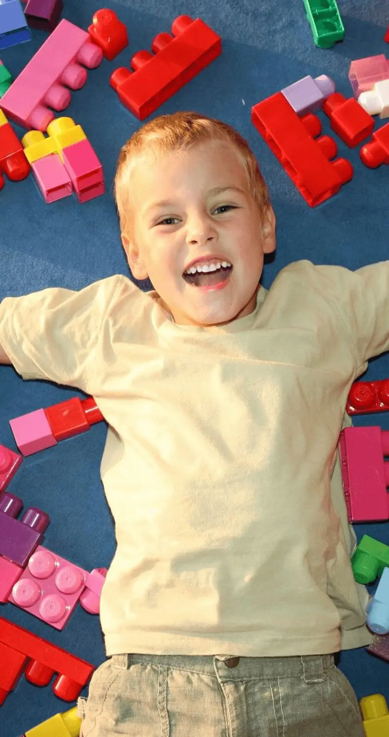 Preschool children learning toy blocks from teacher