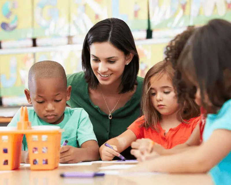 Teachers with children learning at preschool